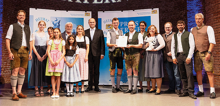 Finanz- und Heimatminister Albert Füracker verlieh den „Heimatpreis Südbayern“ auch an das Schulprojekt „Chiemgauer Mund-ART Weg“ in Oberbayern. Bild: StMFH/Christian Blaschka