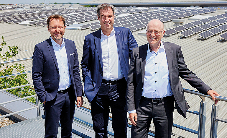 Mit Stefan Rummel (l.) und Dr. Reinhard Pfeiffer (r.) sieht sich Ministerpräsident Dr. Markus Söder die Solaranlage auf dem Dach der Messe München an. Bild: Messe München