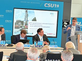 Bild von Personen am Rednerpult