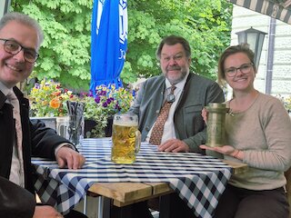 V. l.: Mit einer historischen „Mutter einer bayerischen Maß“ und einem heutigen Maßkrug erinnern Florian Streibl, Fraktionsvorsitzender der Freien Wähler im Bayerischen Landtag, Stefan Thums, Leiter des Bayerischen Landesamts für Maß und Gewicht, und GZ-Verlegerin Theresa von Hassel am Welttag der Metrologie (20. Mai) an die Geschichte des bayerischen Biermaßes. Bild: CH