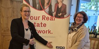 Zwei Personen vor einem EXPO REAL Roll-up